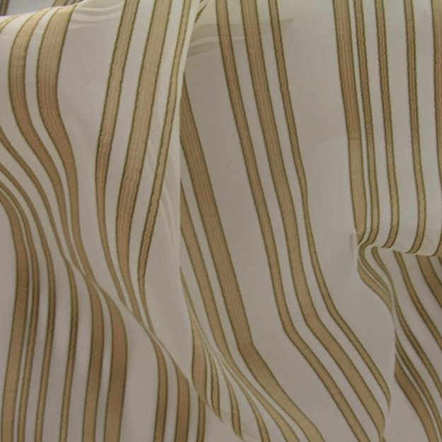 Cream and tan striped fabric in soft folds; lightweight textile with vertical stripe pattern.