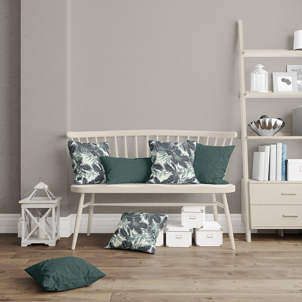 Moonlight Botanical fabric with tropical leaf print; white wooden bench with solid green cushions in a cozy living nook.