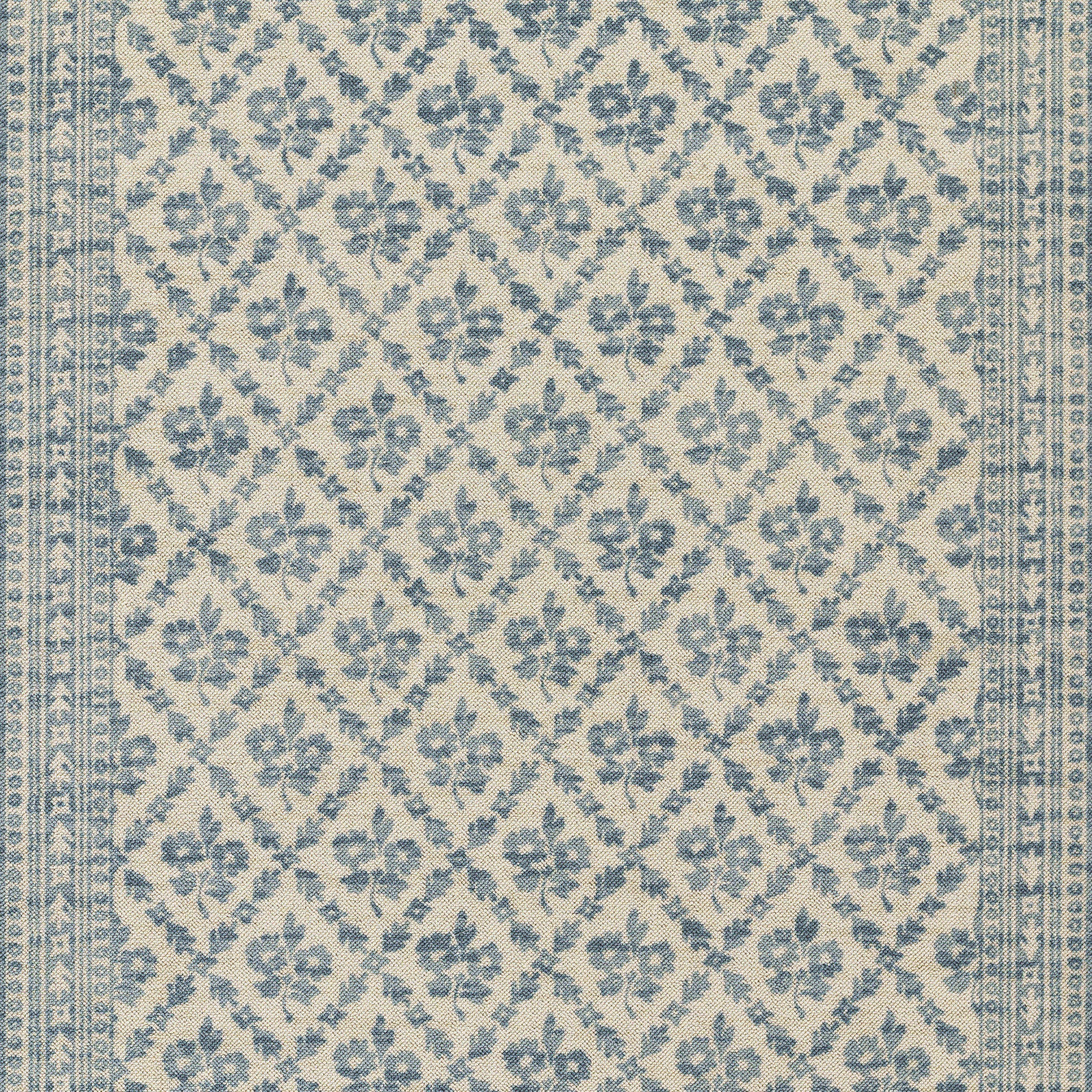 Blue floral lattice rug on beige background with repeating diamond motifs and decorative edge border.