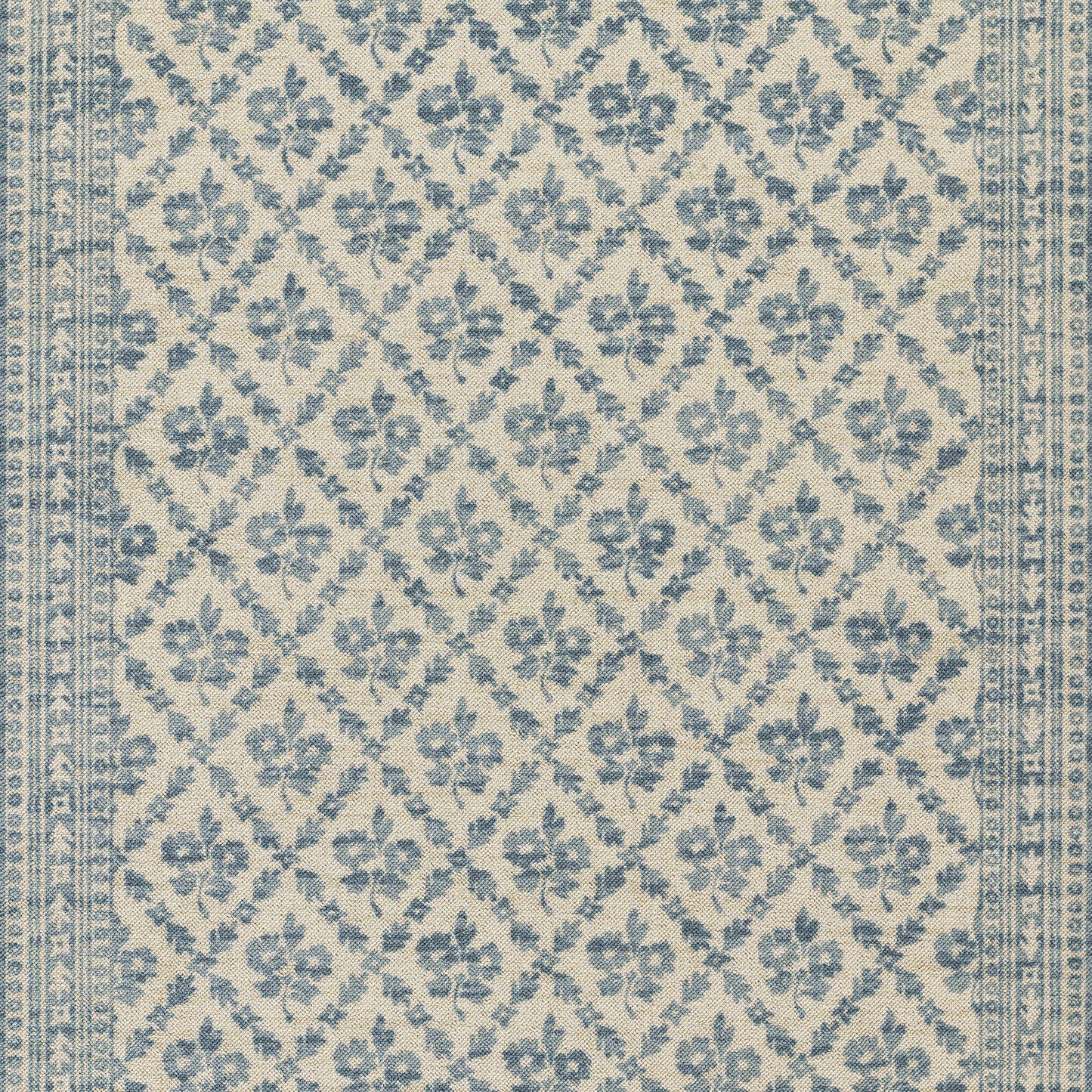 Beige area rug with blue floral lattice pattern and decorative border.