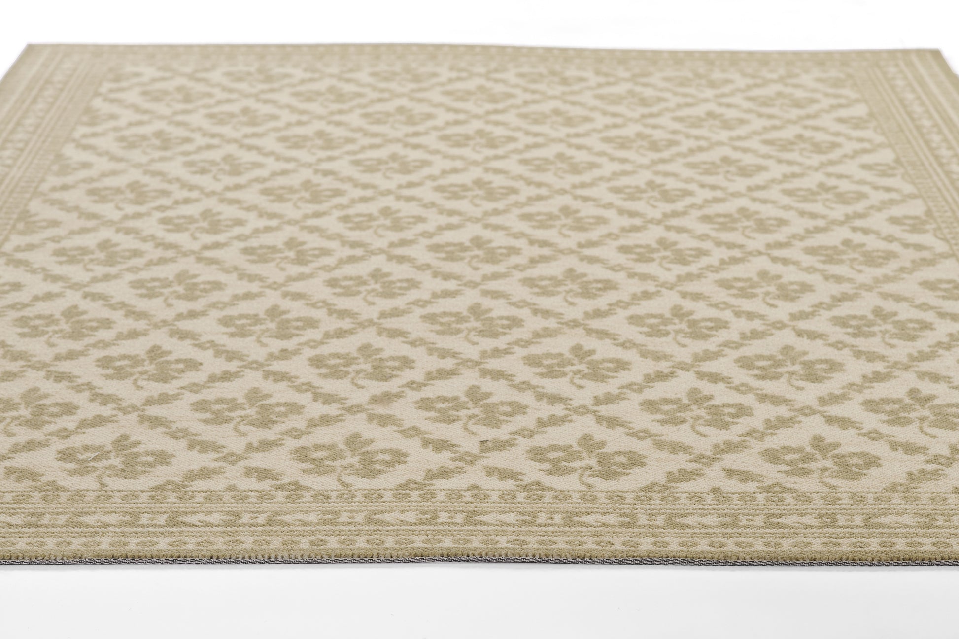 Beige woven area rug with a tonal floral lattice pattern and decorative border.