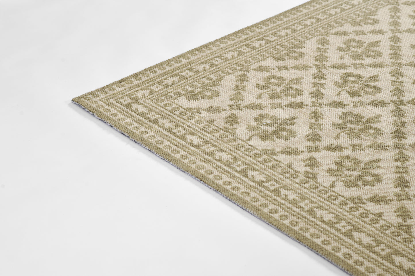 Beige and olive flatweave rug with geometric floral border; rectangular, cozy living room décor.