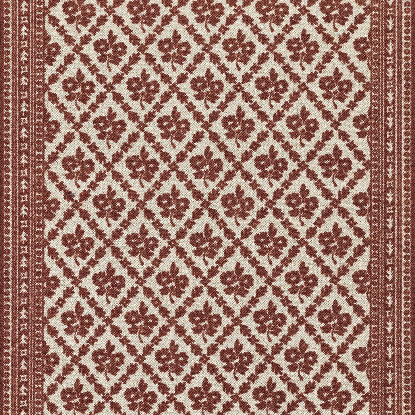 Red and cream patterned rug with floral motifs in a diamond lattice and narrow border.