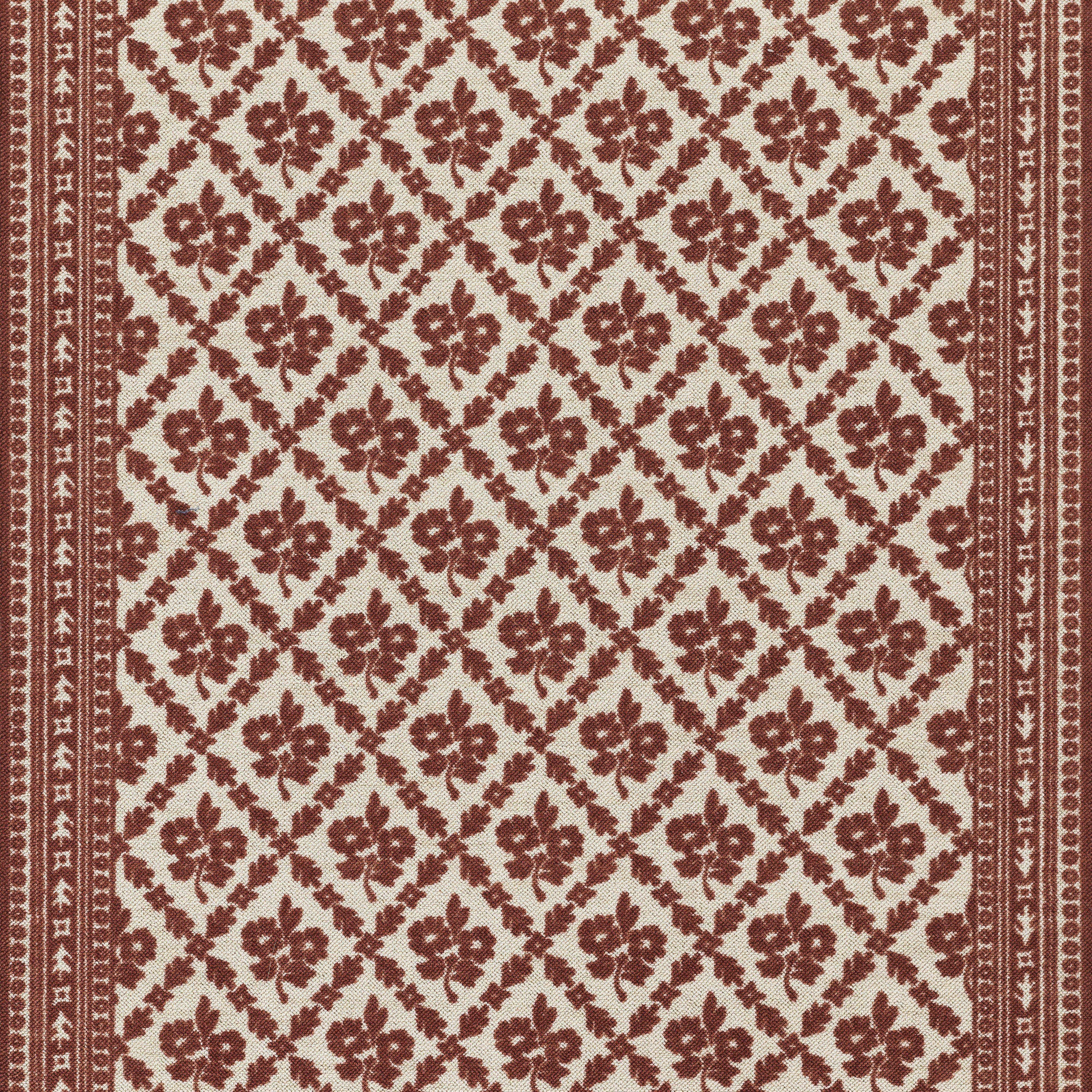 Red and cream patterned rug with floral motifs in a diamond lattice and narrow border.