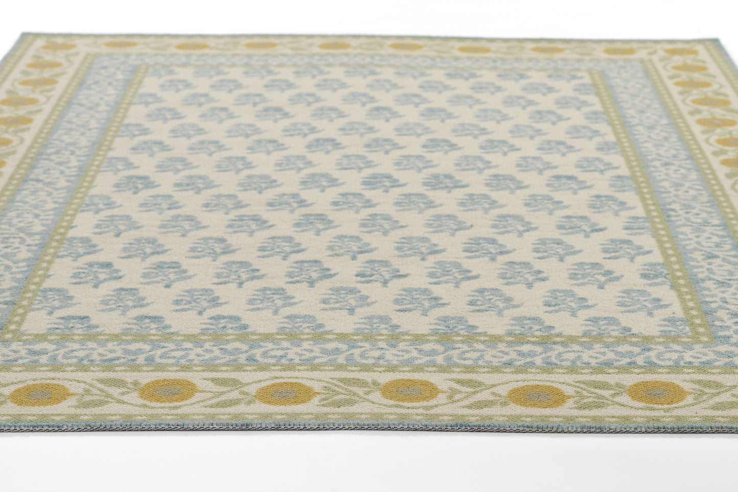 Rectangular runner rug with cream field, blue floral motifs, pale green borders and yellow circular motifs; fringed edges.