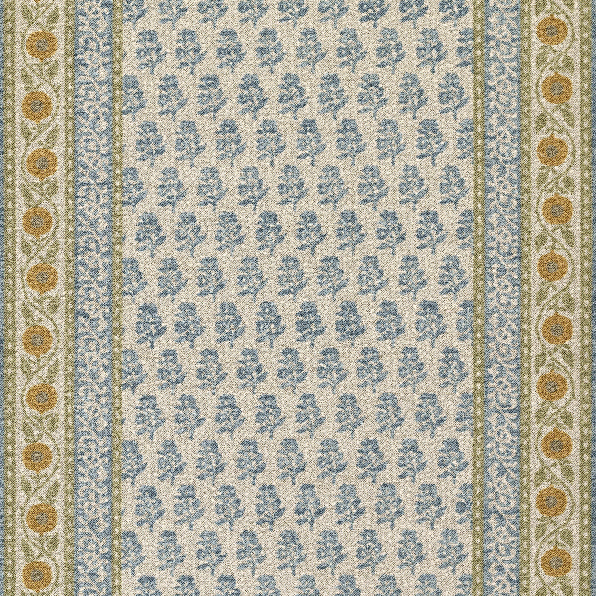 Beige woven rug with blue floral sprigs; bordered by blue patterned borders and olive-green edges with orange circle motifs.