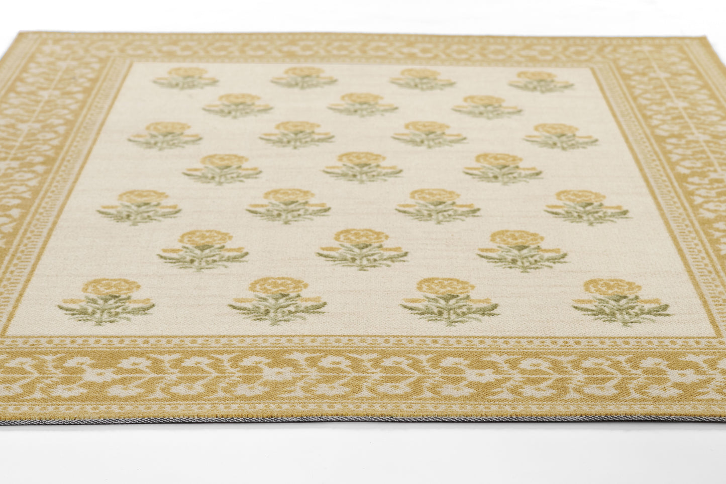 Cream area rug with repeating gold rose motifs, green leaves, and a wide gold patterned border.