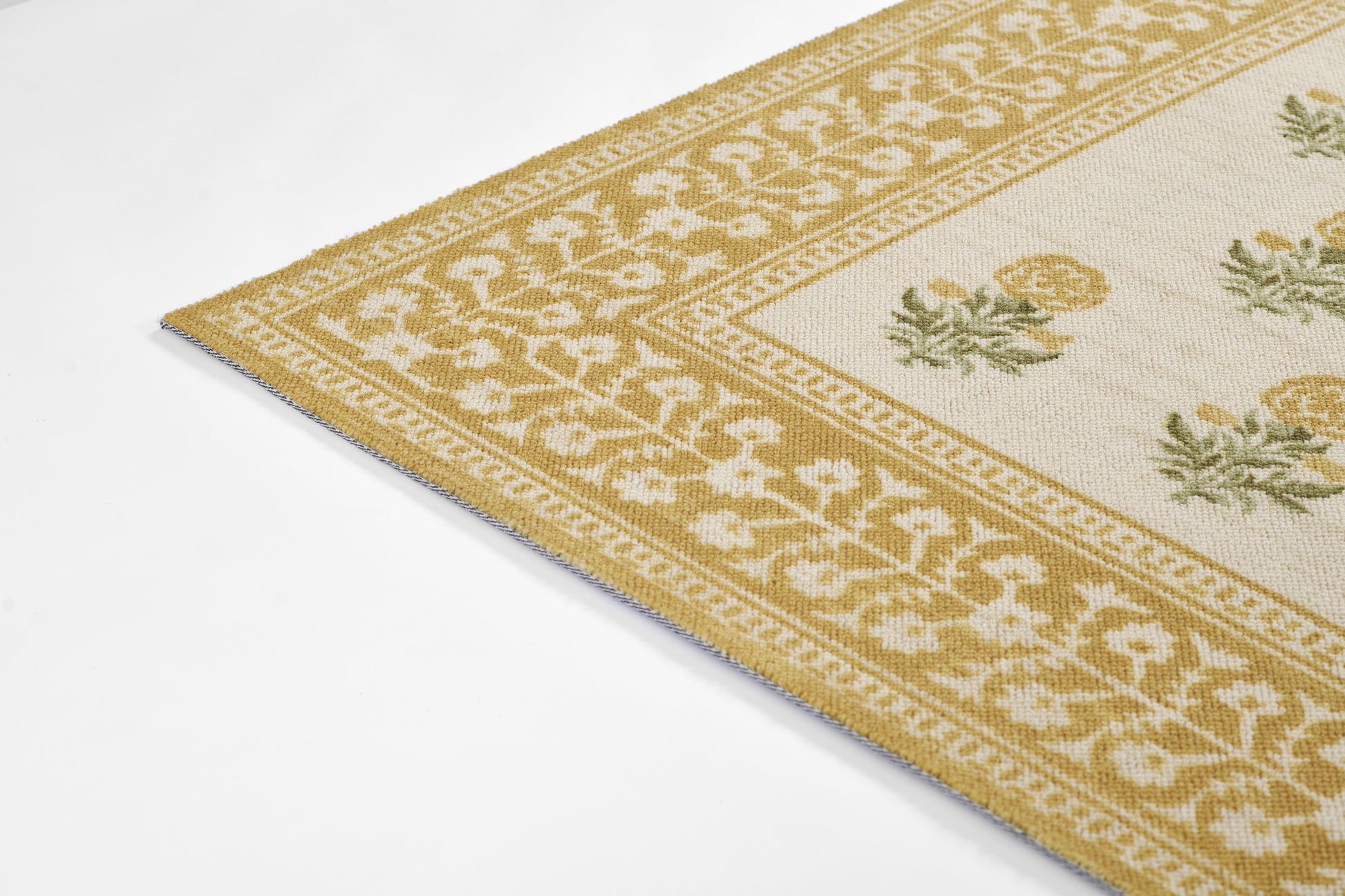 Woven rug with gold border and cream center, yellow floral motifs and green leaves.