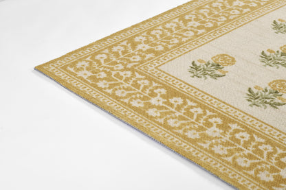 Beige and gold woven rug with ivory central field and a repeating floral border in gold tones.