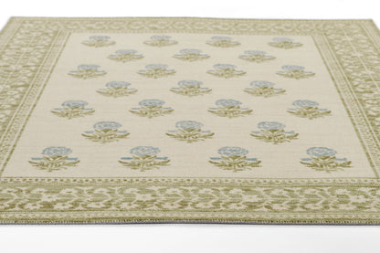 Beige area rug with pale blue floral rosettes, sage-green leaves, and an ornate olive border; classic, low-pile design.