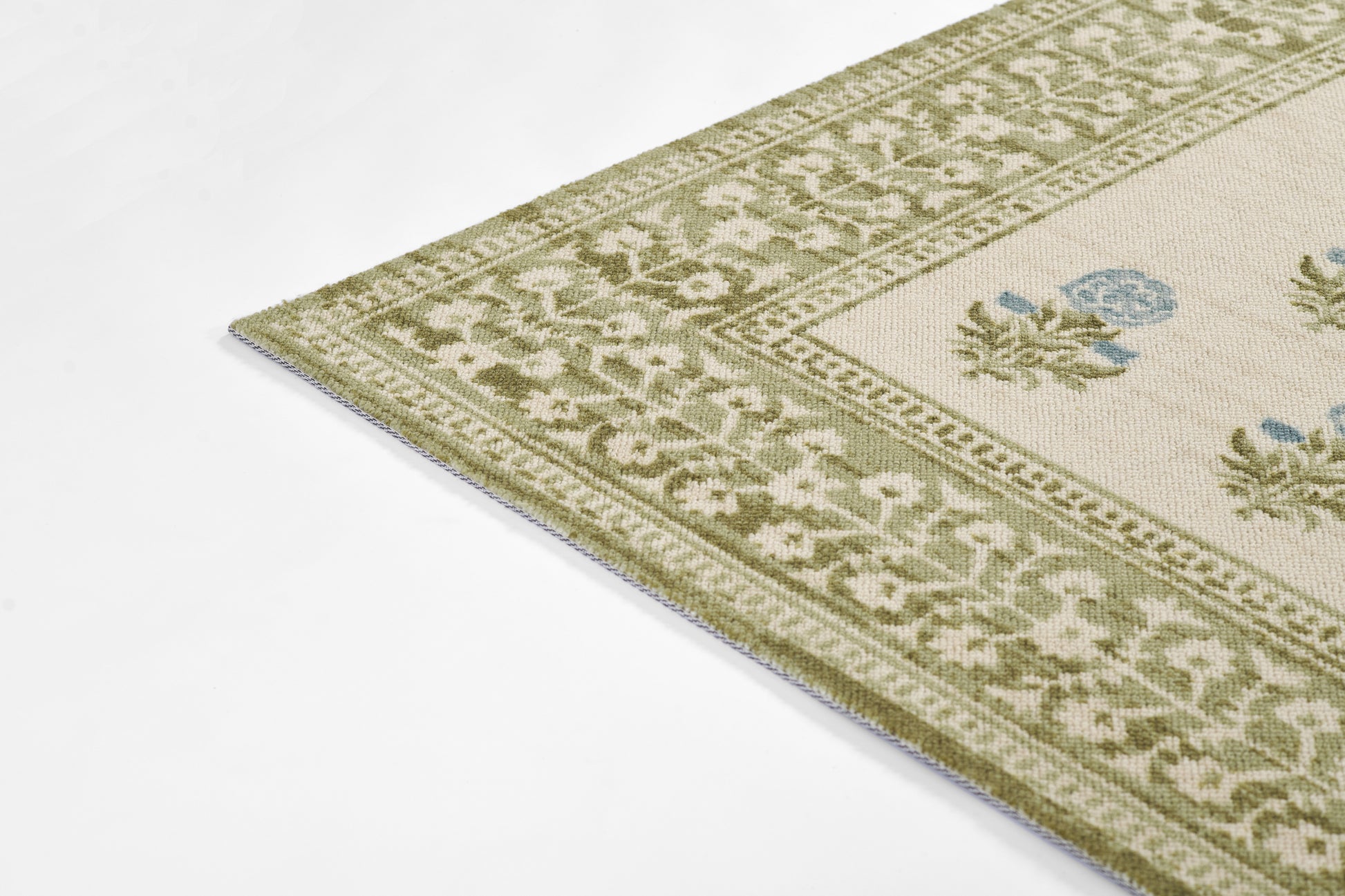 Olive-green border rug with cream central field & blue floral motifs; decorative floral border.
