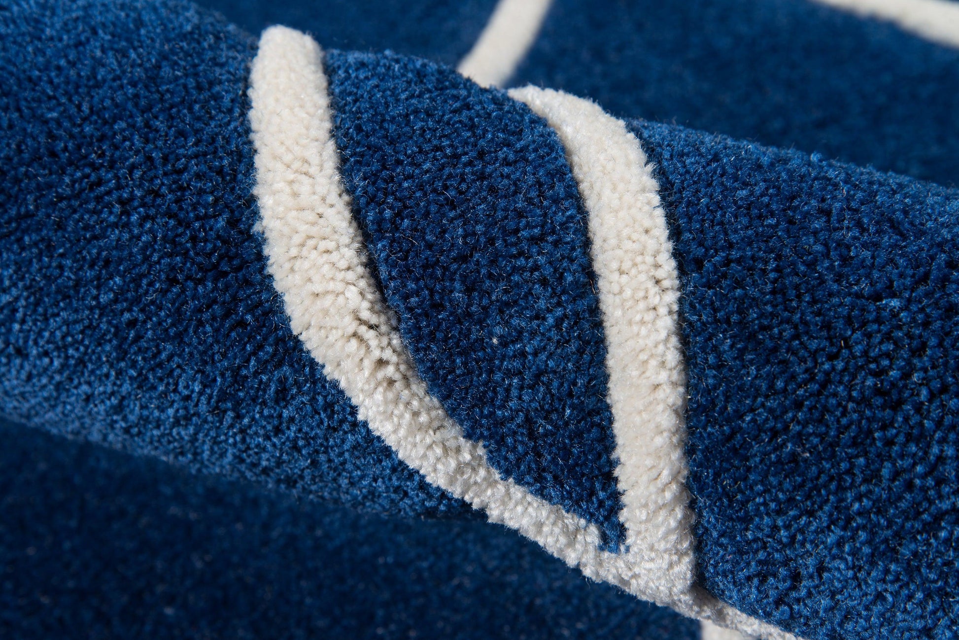 Close-up of navy blue terry cloth with thick white piping trim.