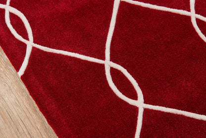 Red runner rug with white curved line motif on wooden floor.