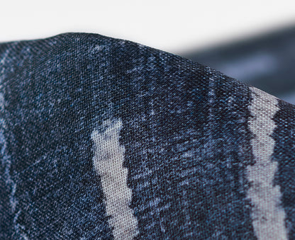 Close-up of dark blue rug with a pale vertical stripe; textured weave.