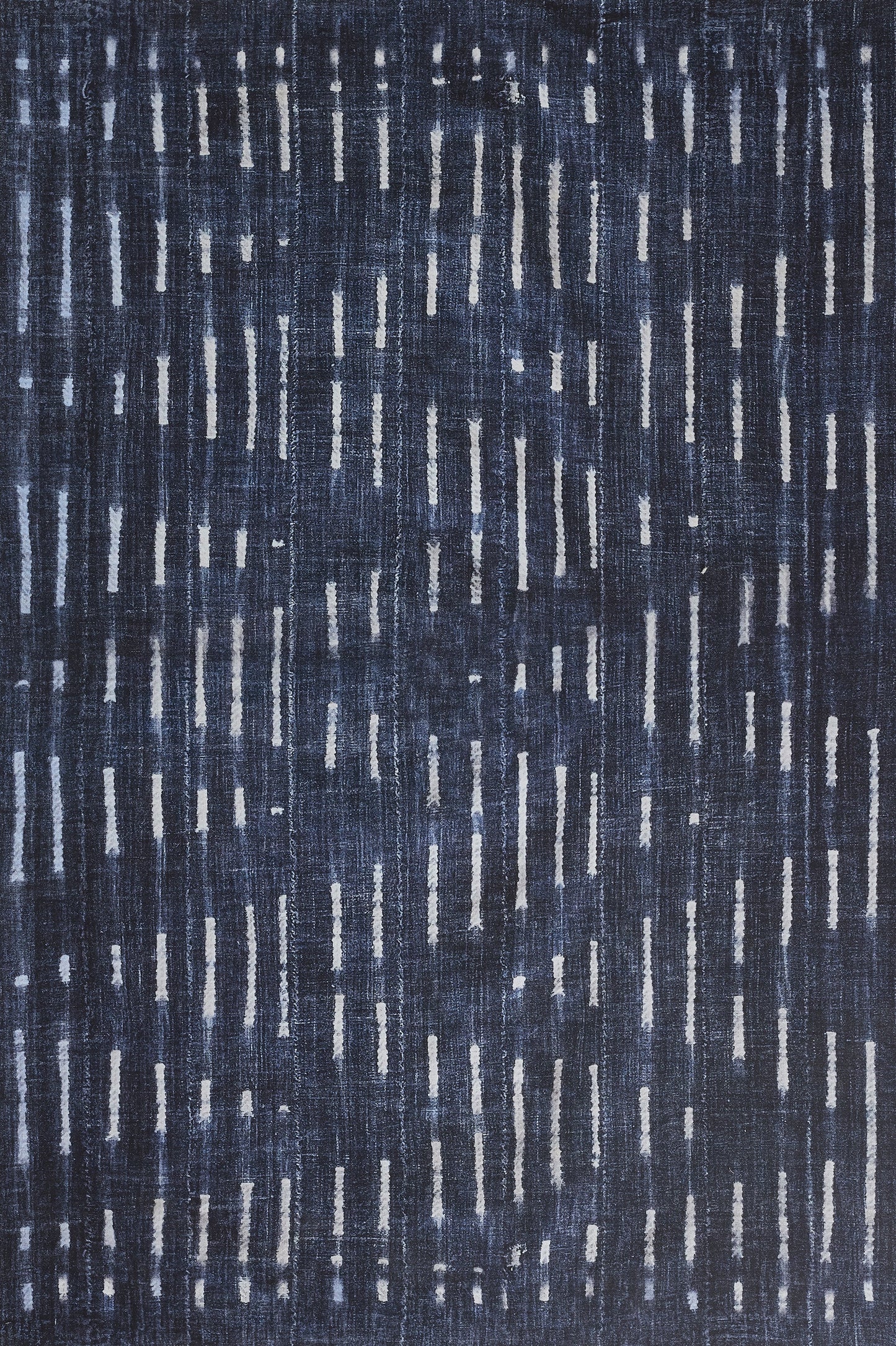 Navy blue rug with pale gray vertical dash motifs for a modern, textured, denim-inspired look.