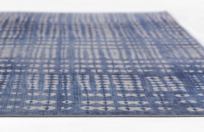 Blue woven rug with pale geometric diamond and circle motifs in vertical rows; denim-like texture.