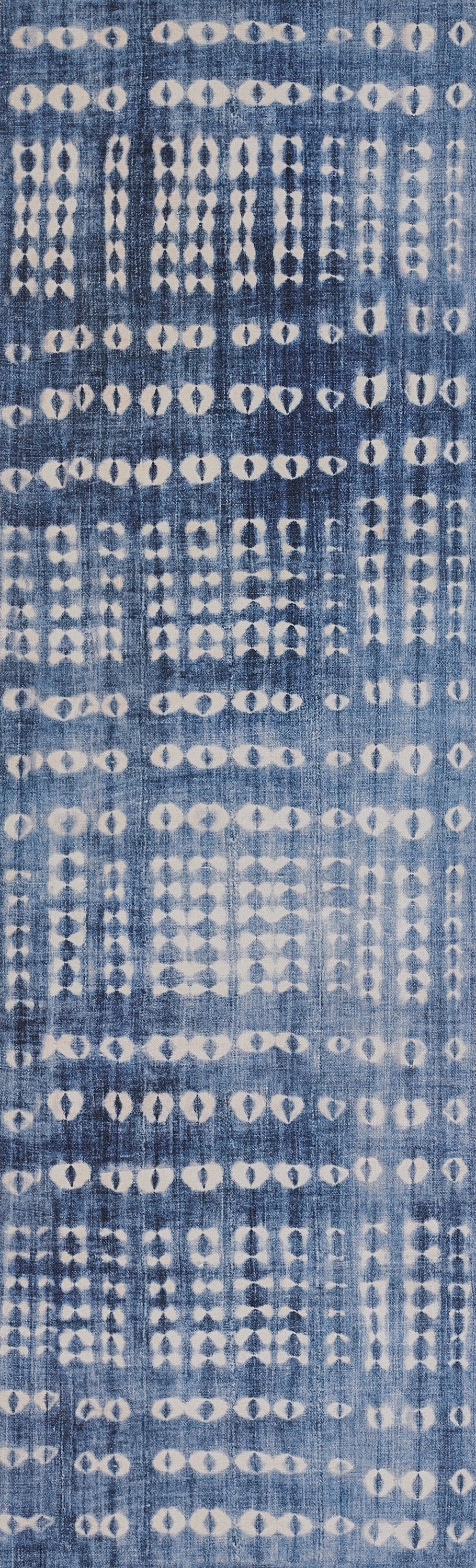 Indigo blue rug with white diamond-dot ikat motifs.