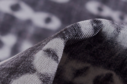 Close-up of a grey and black patterned rug with a woven texture and folded edge.