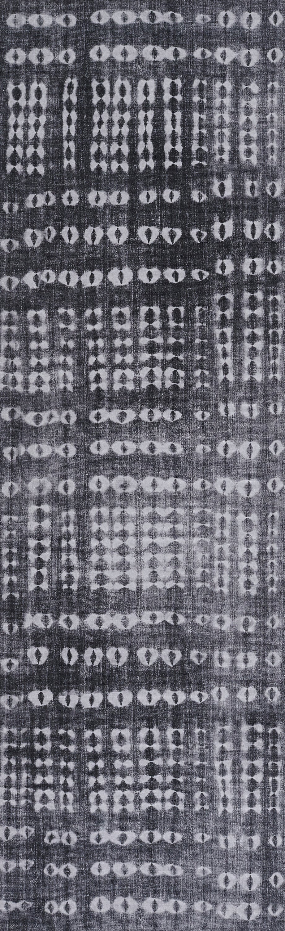 Dark indigo rug with white batik-style geometric pattern of diamonds and circles in vertical bands.