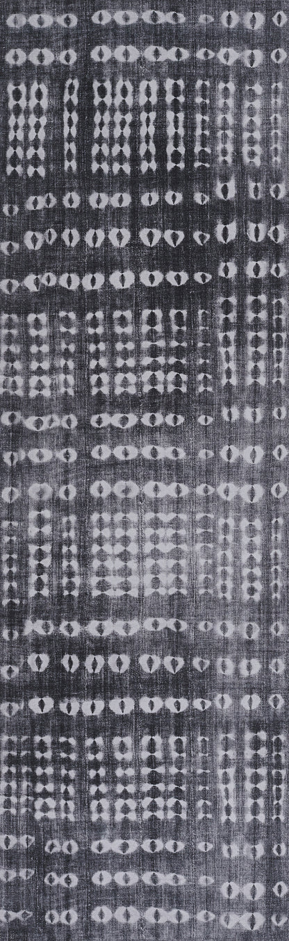 Dark indigo rug with white batik-style geometric pattern of diamonds and circles in vertical bands.