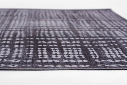Dark purple woven rug with light gray geometric diamond pattern; low-pile, rectangular area rug.