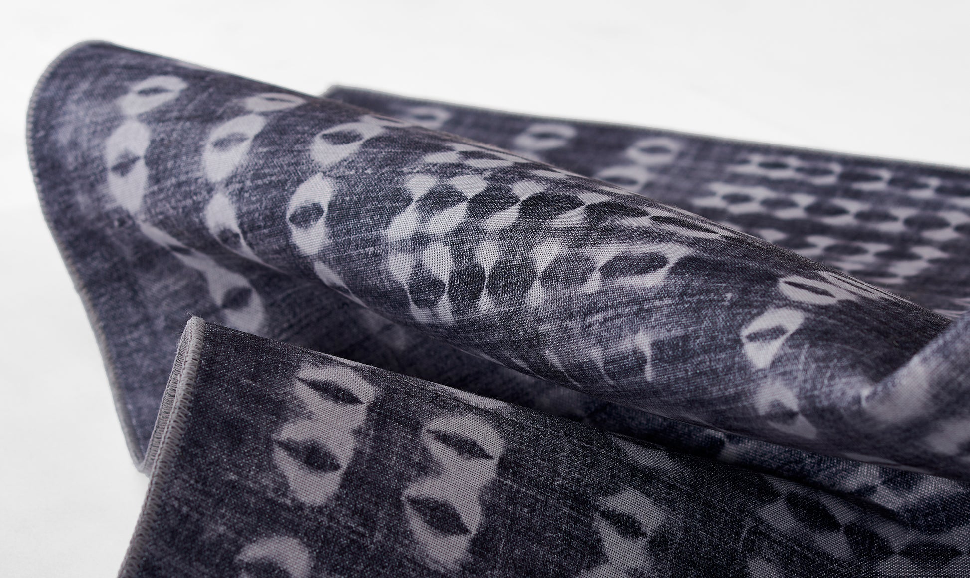 Dark indigo woven fabric with pale gray irregular spots, folded textile suitable as scarf or throw.