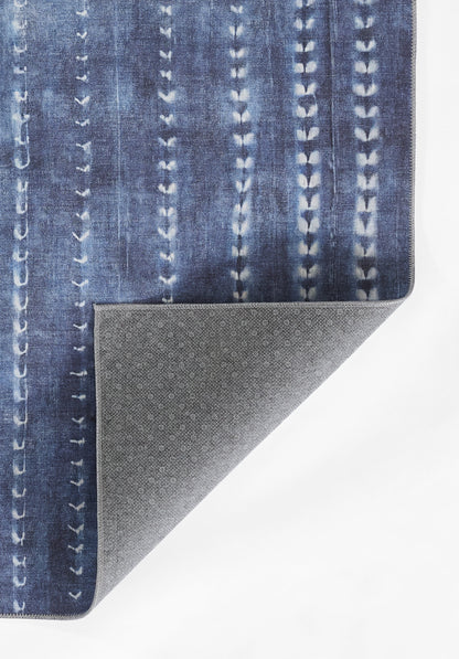 Blue denim-patterned rug with vertical stitched stripes; folded corner shows gray speckled non-slip backing.