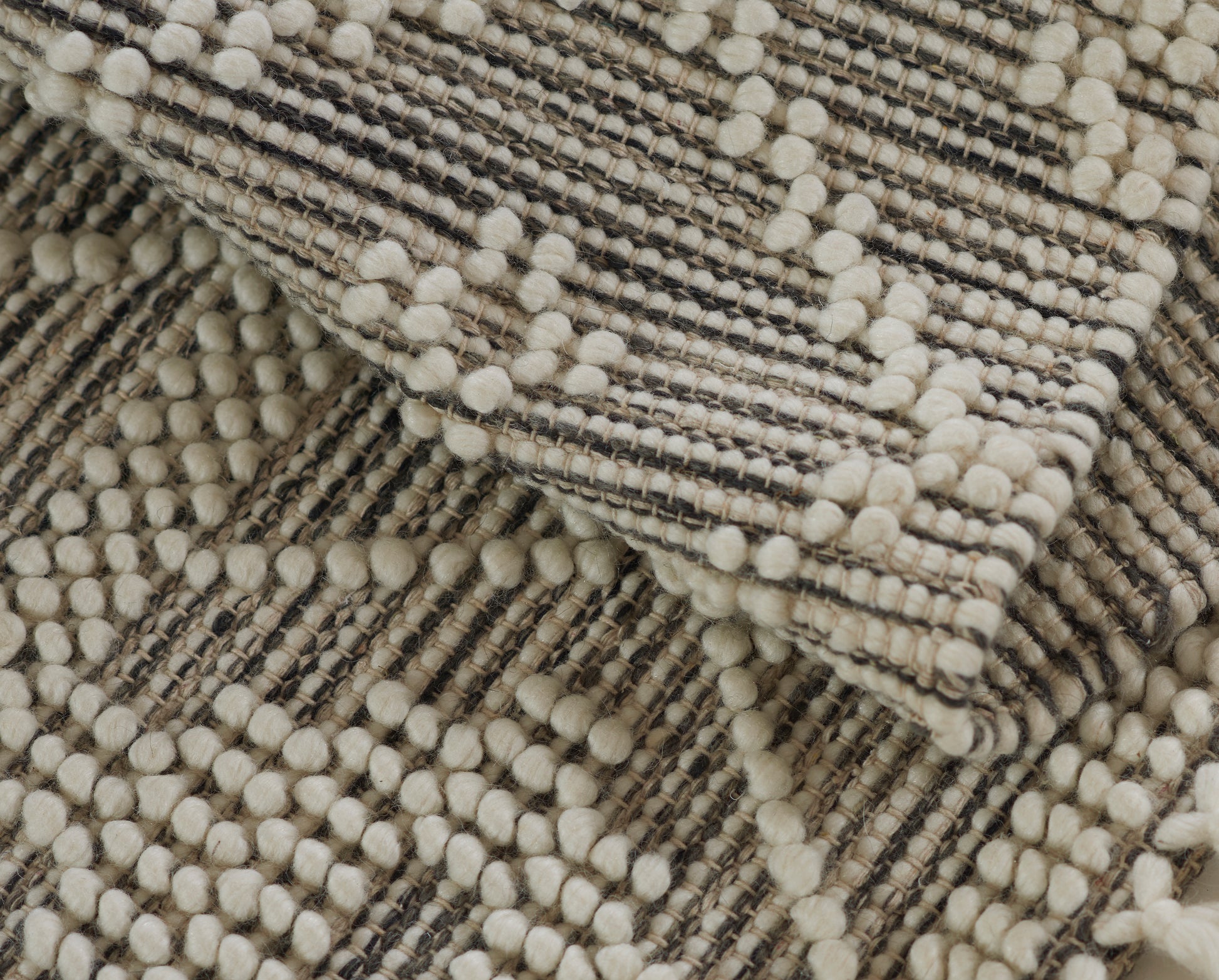 Beige boucle rug with cream pom-pom yarns and grey striped weave, 4' x 6'.