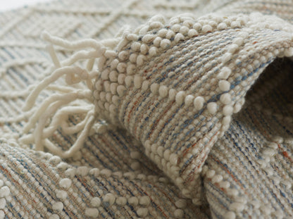 Cream boucle woven throw with chunky pom-pom fringe, pale blue & ivory stripes.