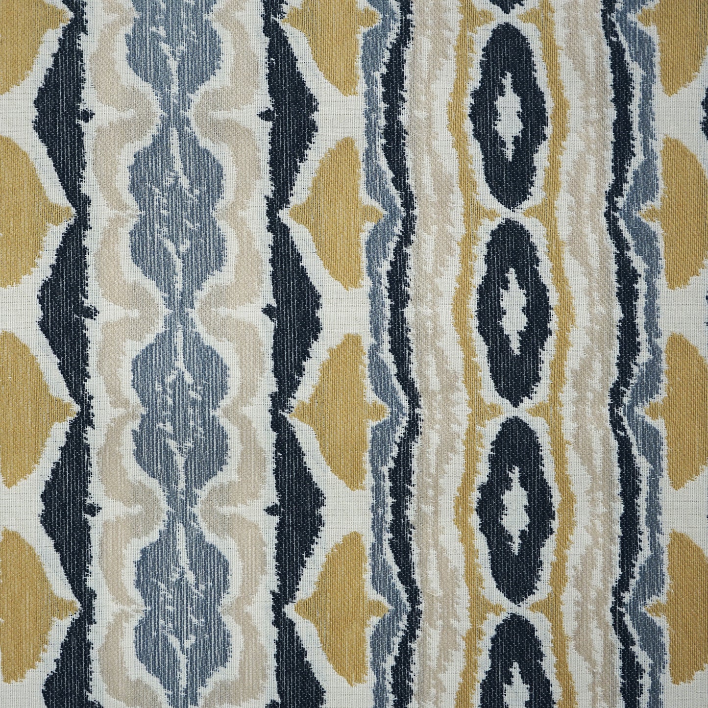 Geometric striped fabric in navy, mustard, light blue and cream with ikat-style diamonds; woven textile.