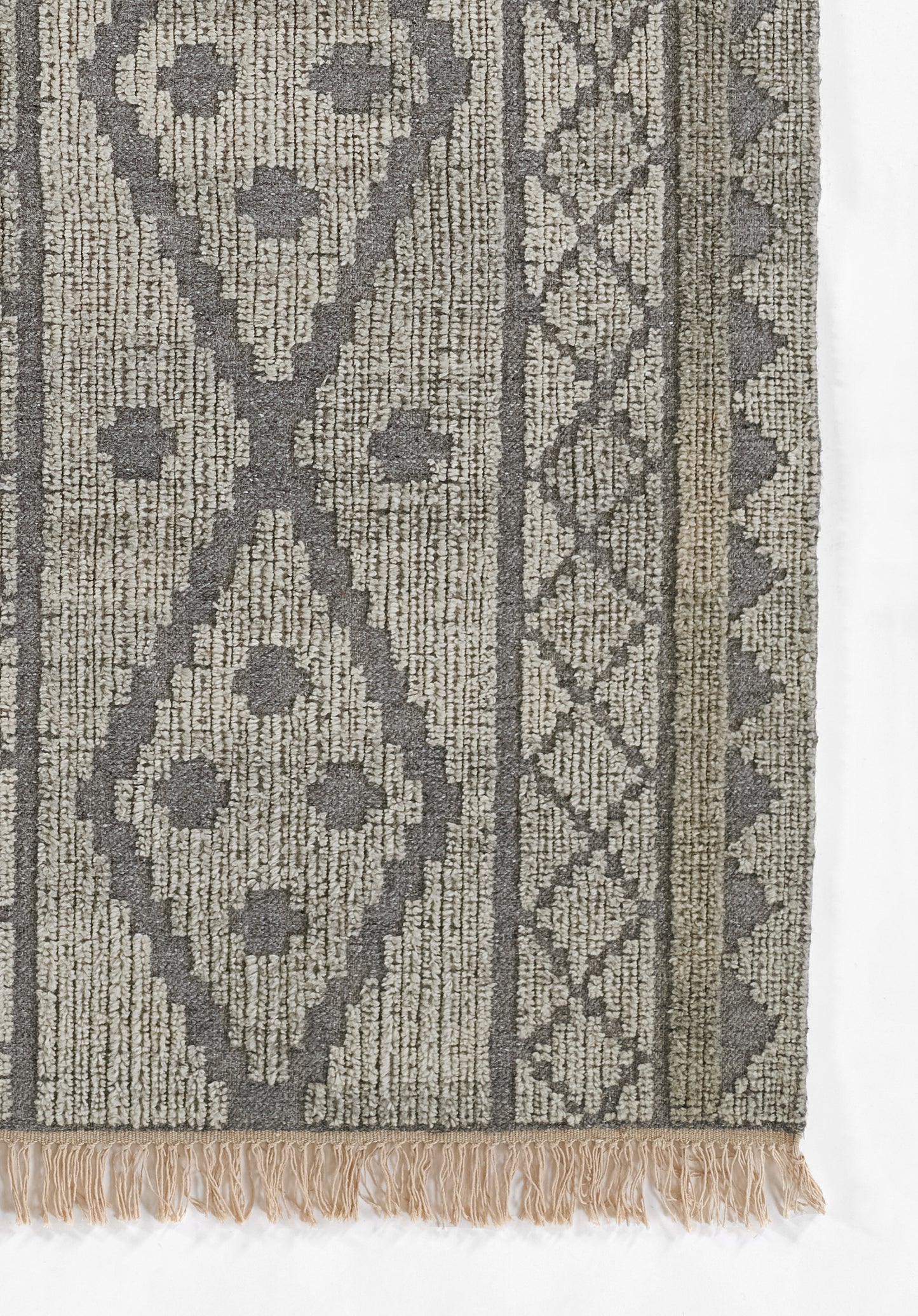 Gray and beige woven rug with geometric diamond motifs and fringe along bottom edge.