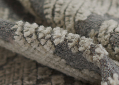 Close-up of grey & ivory fluffy boucle knit with chunky loops, a cozy throw blanket texture.