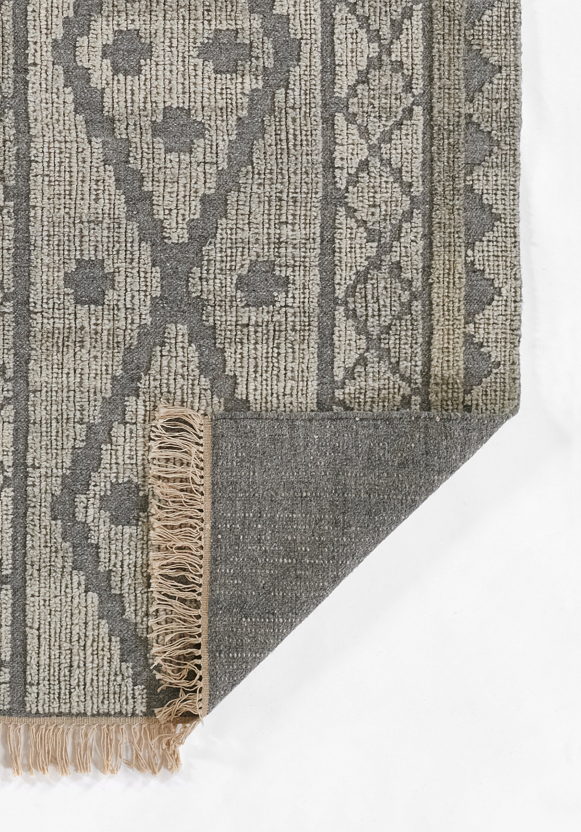 Gray geometric rug with lattice and diamond motifs, soft woven texture, beige fringe along edges.