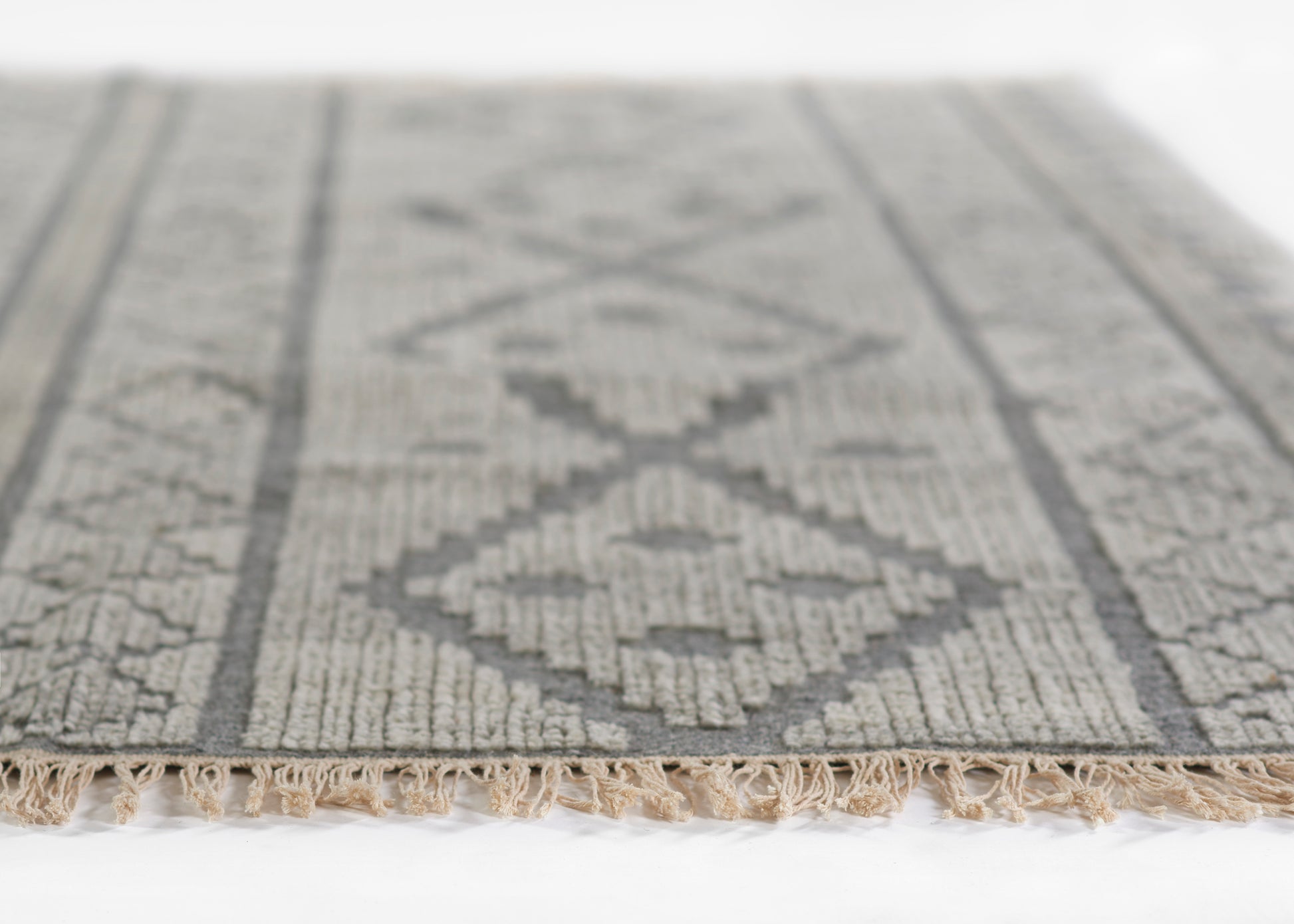 Gray diamond-pattern rug (8' x 10') with textured weave and beige fringe along edges.