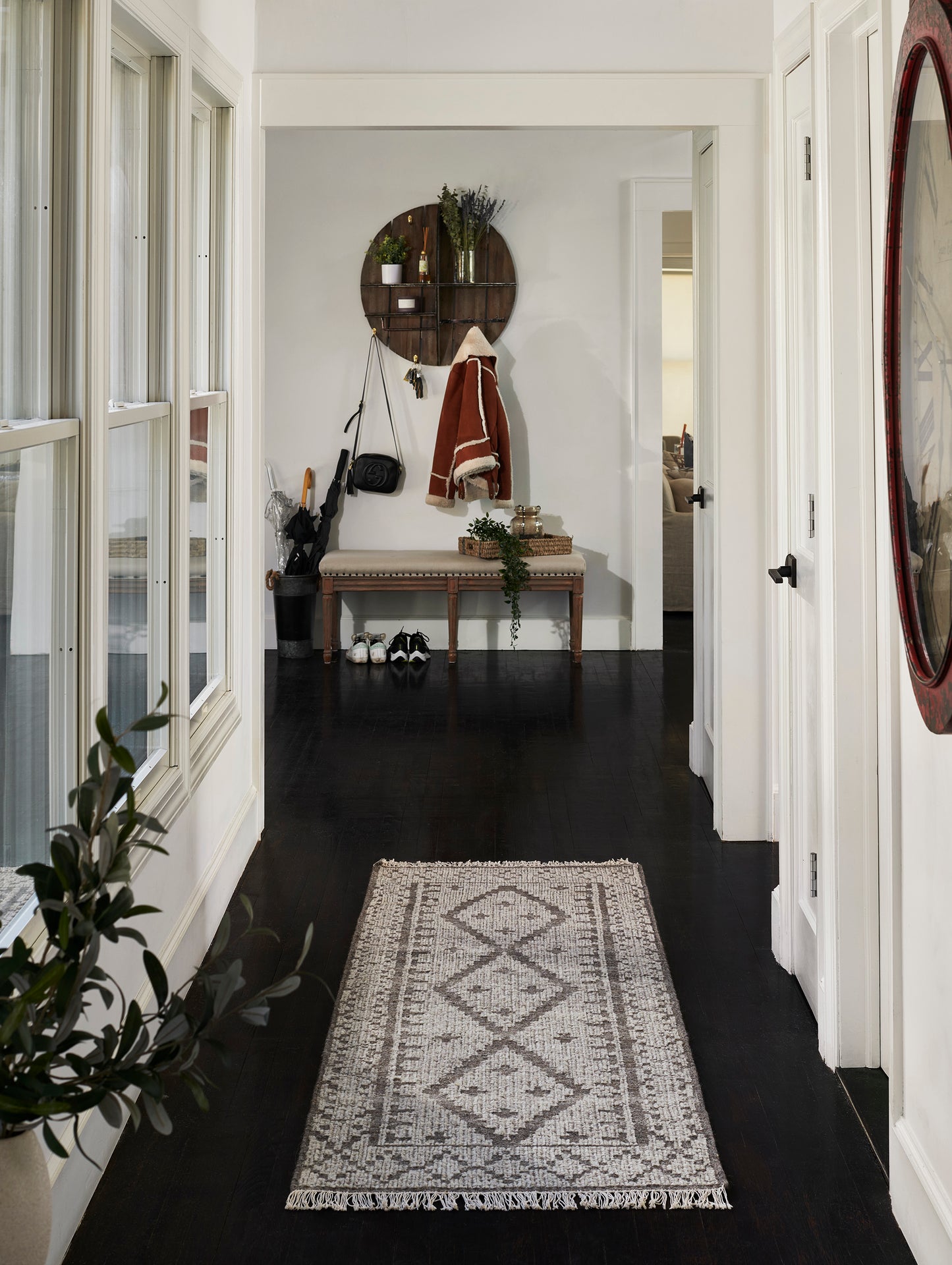 Gray and ivory geometric diamond runner rug with fringe in an entry hall.