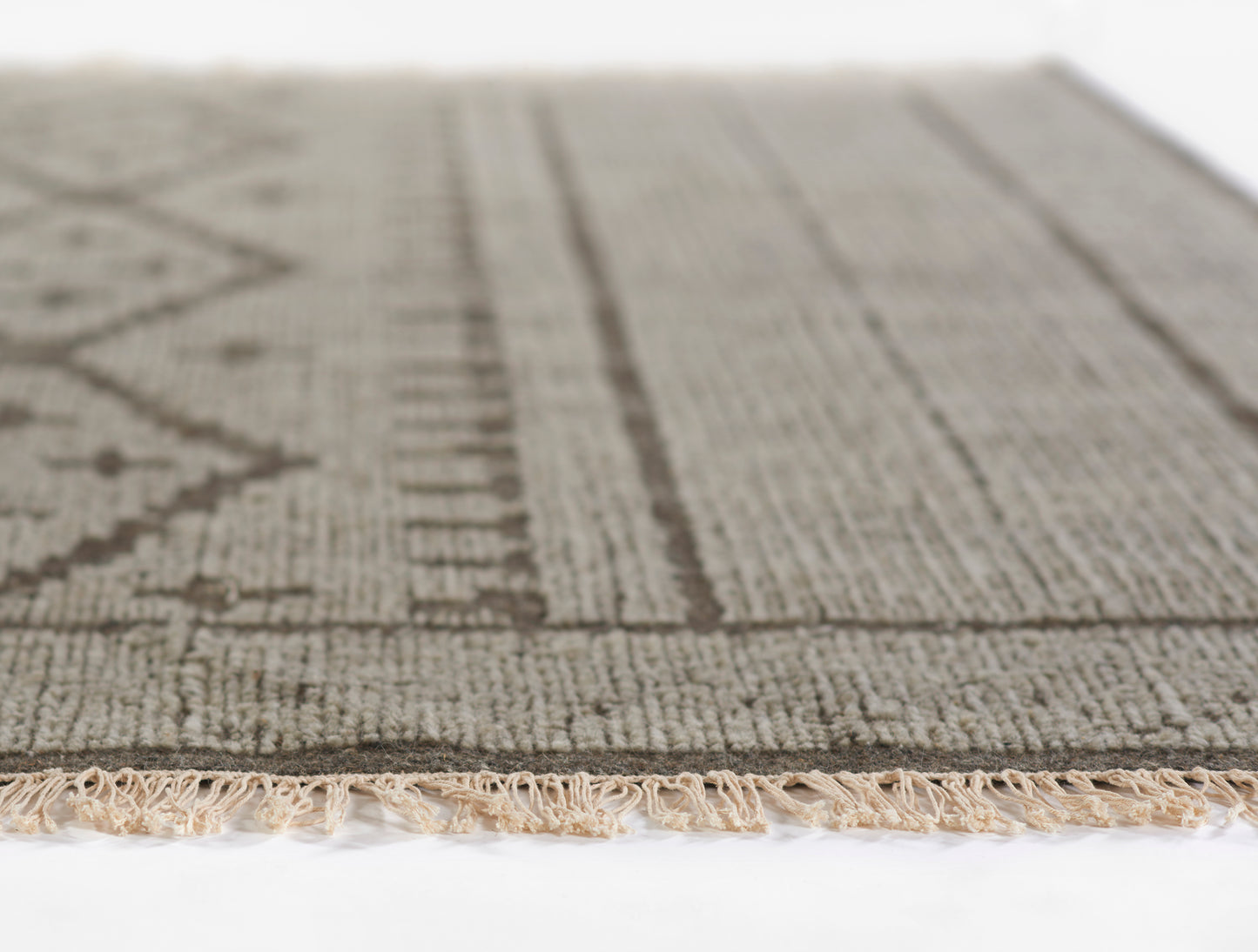 Neutral gray & taupe woven rug with geometric pattern & fringed edge, ideal for living room or entryway.