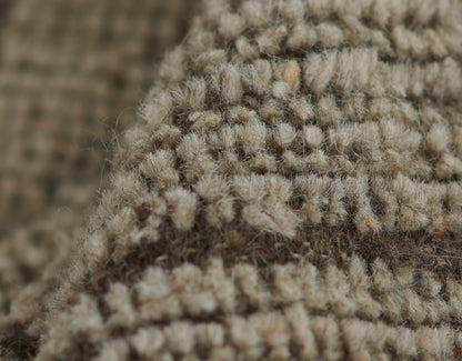 Beige boucle loop-pile rug close-up; natural soft fibers with chunky tufted loops for cozy living room decor.