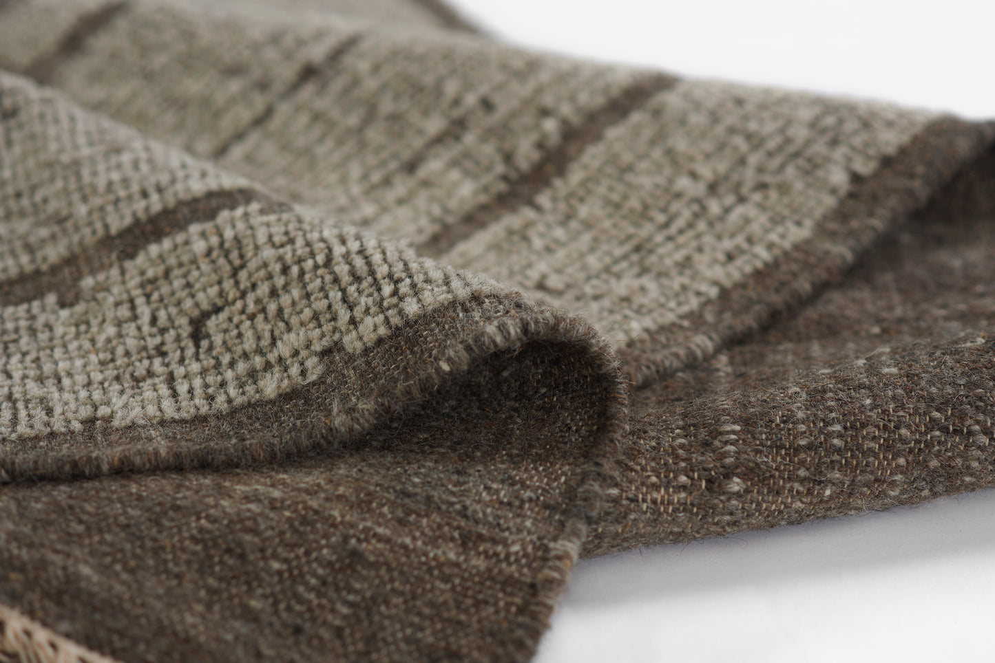 Taupe and brown striped woven blanket with soft, chunky texture, folded to reveal front and back layers.