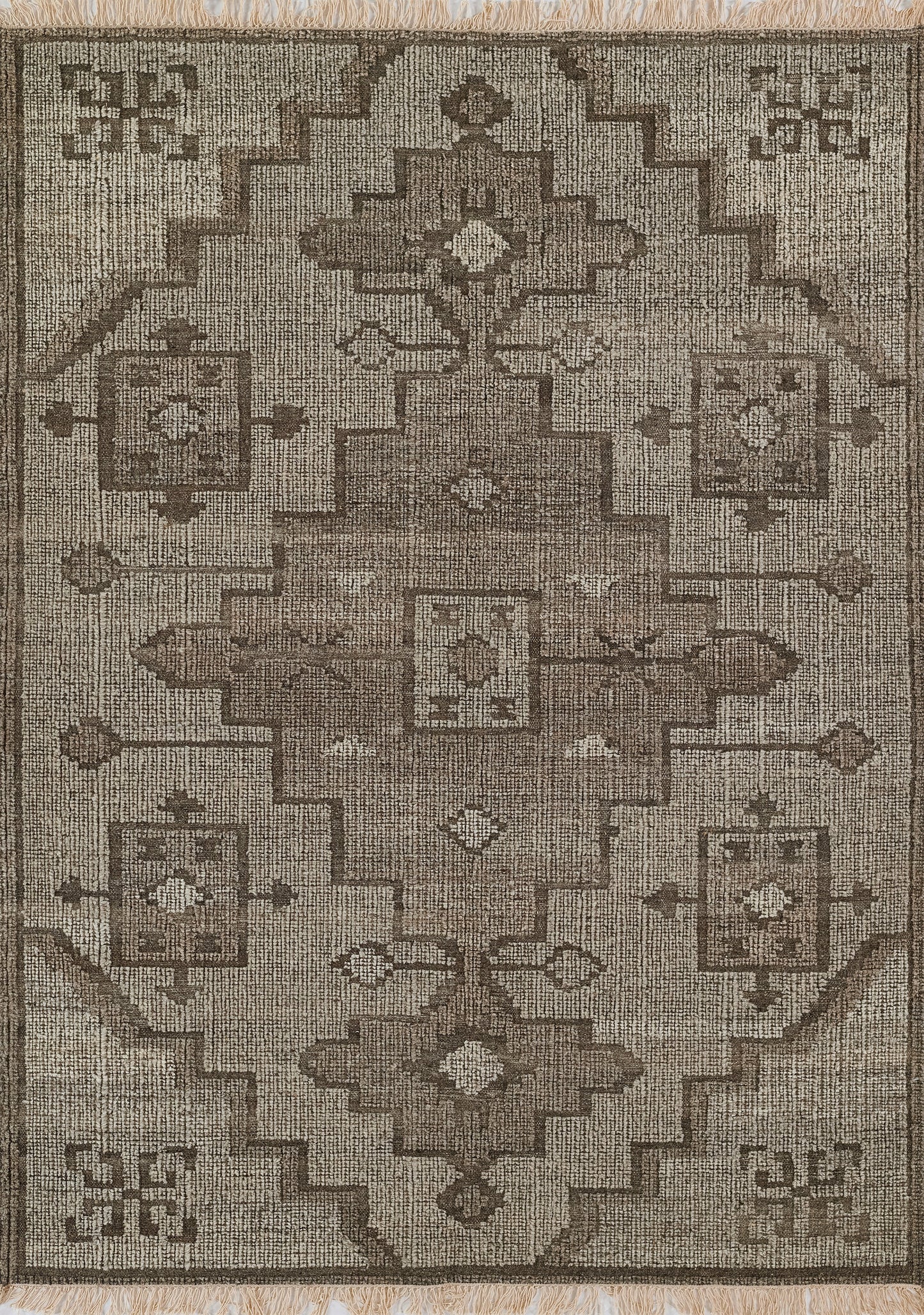 Neutral brown-and-beige oriental rug with stepped geometric borders, central medallion, floral square accents, fringed ends.