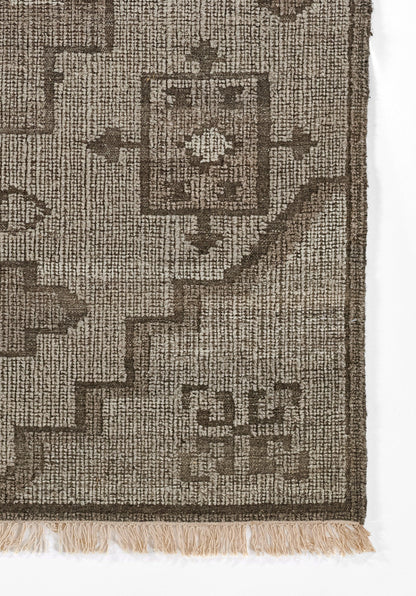 Natural brown woven rug with geometric border and centered square motif, fringed edge for rustic home decor.