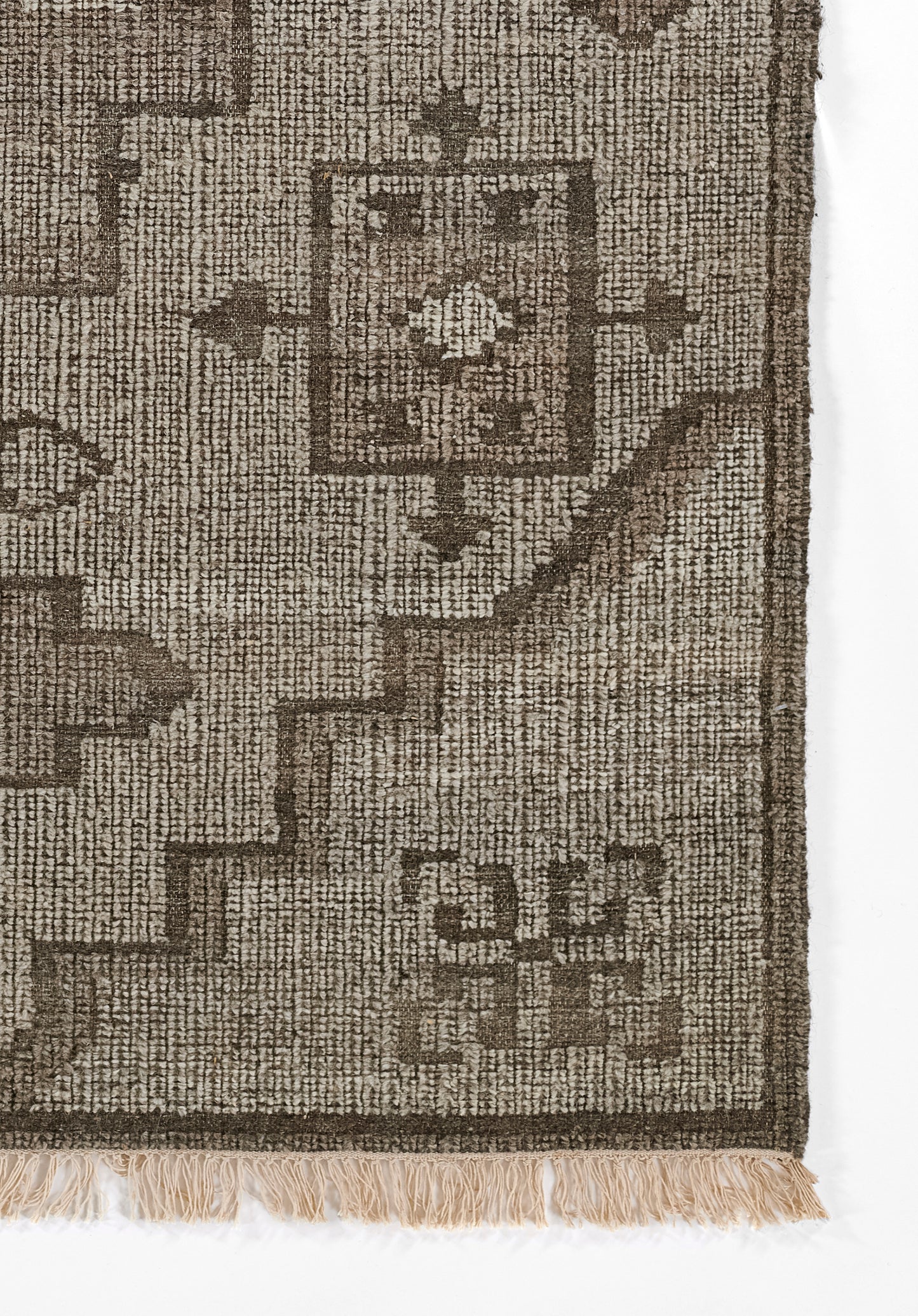 Brown and natural-tan woven rug with geometric motifs and fringe edge.