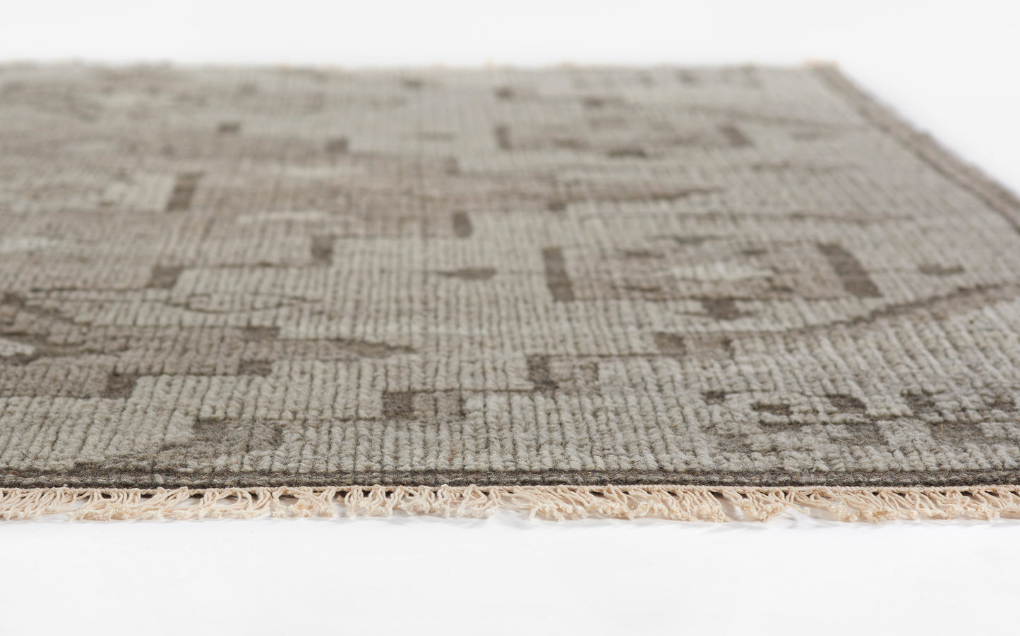 Neutral beige and taupe geometric flatwoven rug with cream fringe.