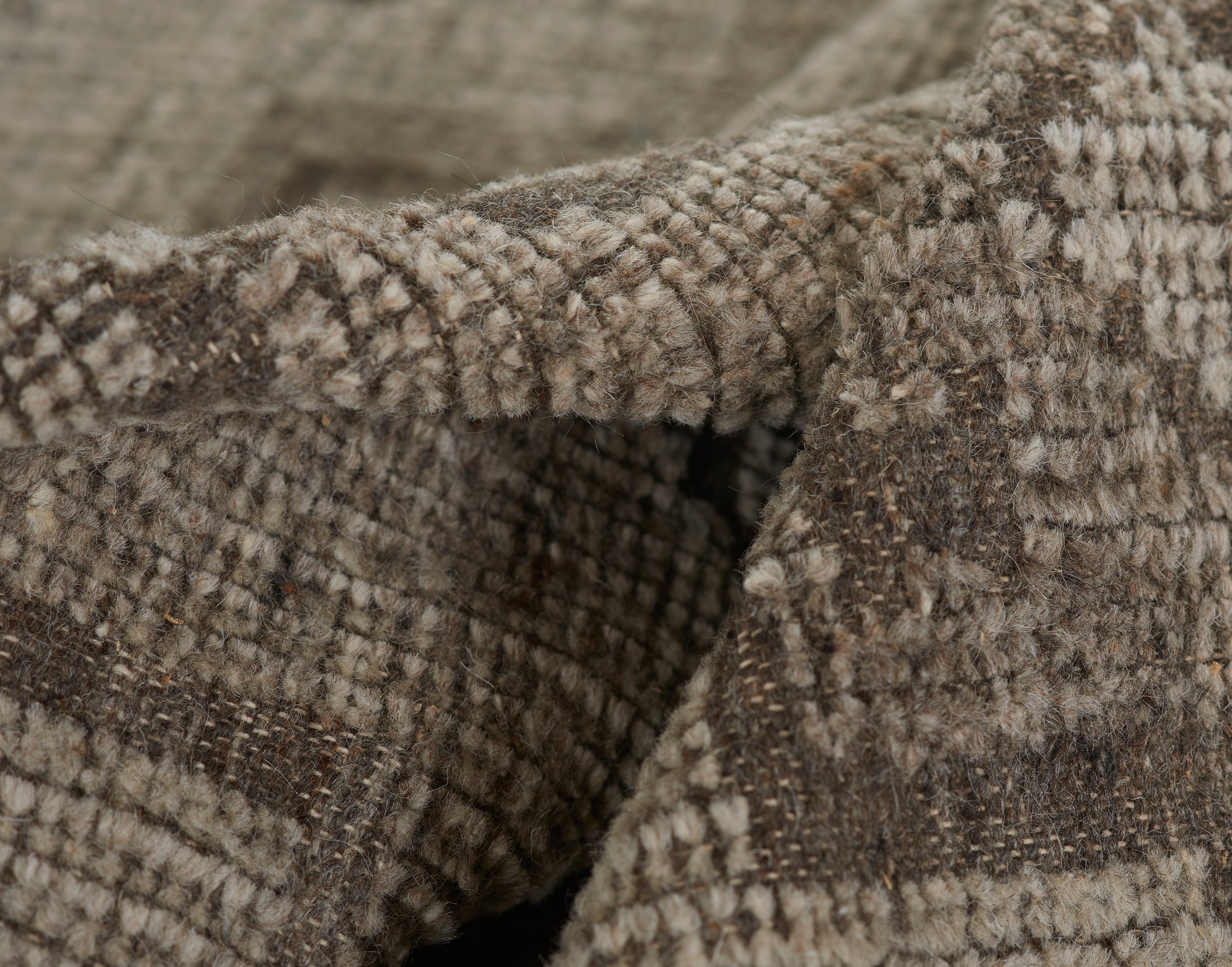 Close-up of brown and beige tweed wool blanket with plaid pattern and soft, fuzzy texture.