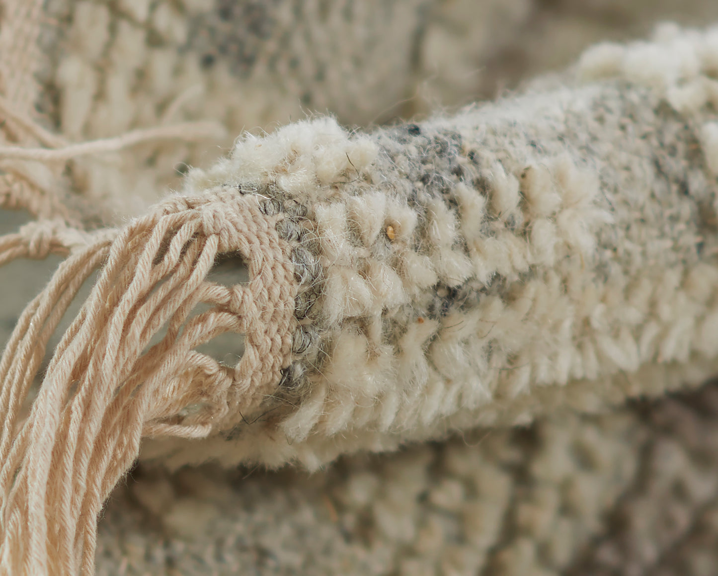 Ivory boucle shag rug with chunky weave and beige tassel fringe, boho cozy decor.
