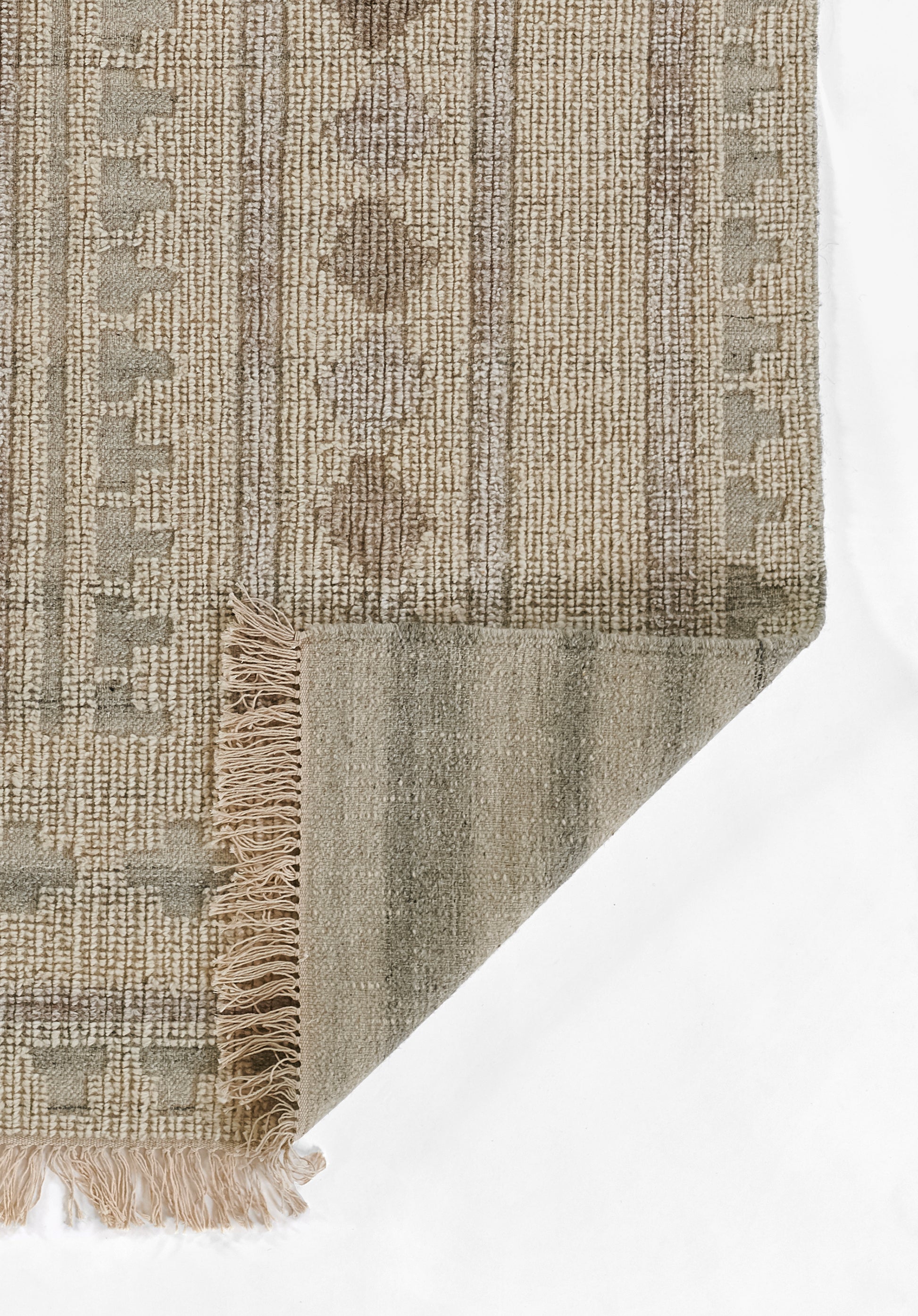 Ivory & beige woven rug with geometric vertical stripes, fringed edge, folded corner showing reverse.