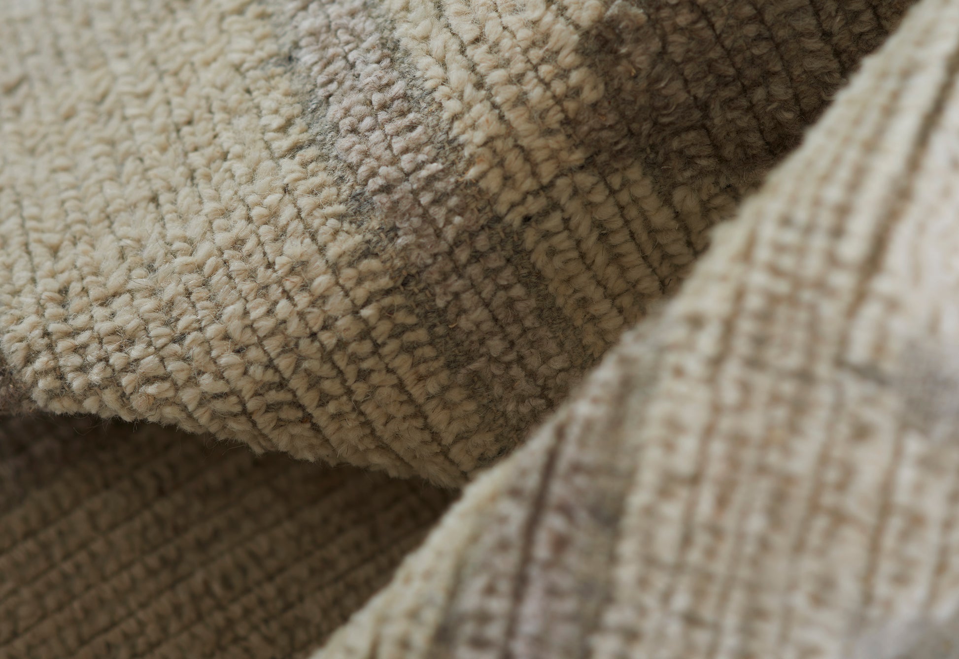 Close-up of beige boucle rug fabric with plush loop pile, folded, showing a soft, cozy 2'3" x 8' runner rug.