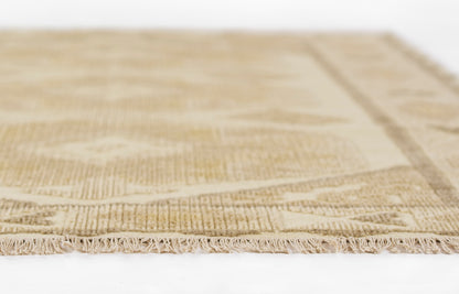 Natural beige woven rug with tassel fringe, textured pattern in warm neutral tones.