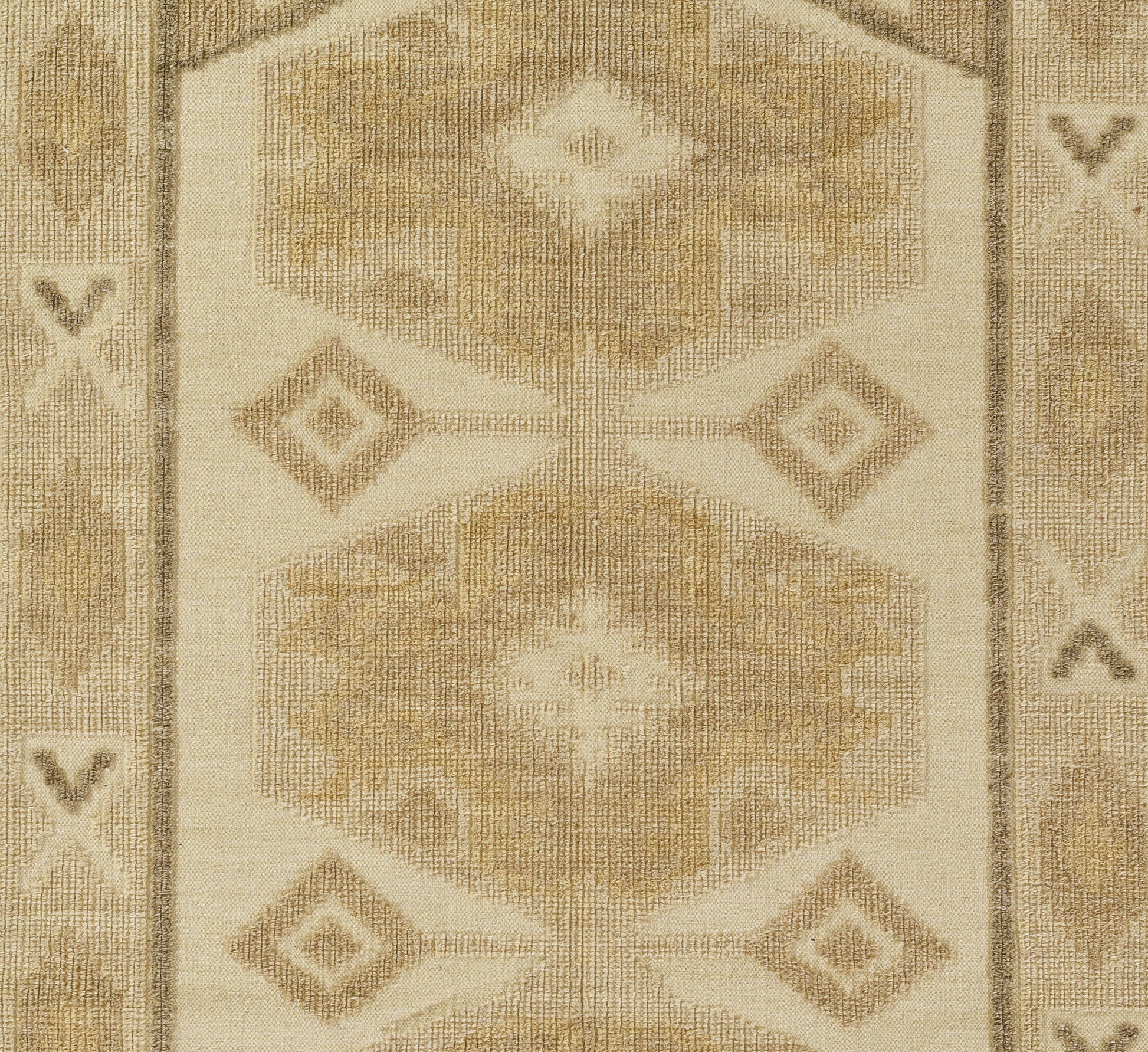 Beige woven rug with geometric hex and diamond motifs in cream and tan, bordered edges