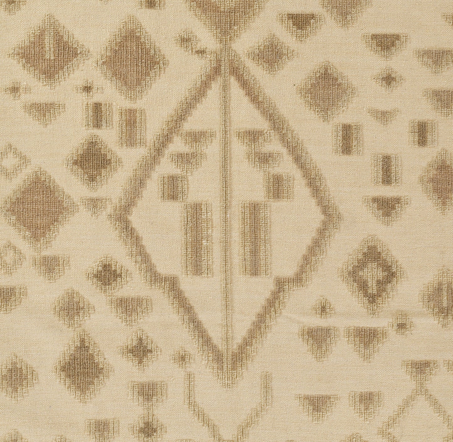 Beige kilim-style rug with brown diamonds and geometric motifs; woven texture, neutral floor decor.