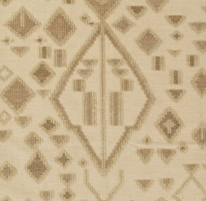 Beige woven rug with tan diamond motifs and geometric lines in a kilim-inspired pattern.